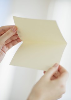 Hands opening a blank card.