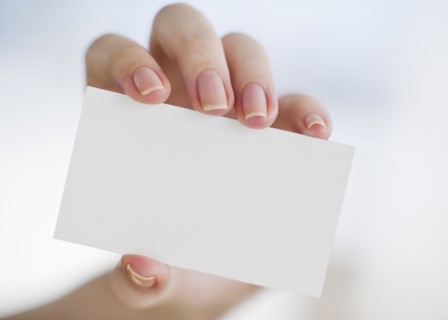 Hand holding a blank business card.