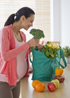 Pregnant woman unpacking groceries.