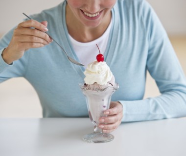 Woman eating ice cream sundae.