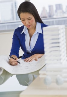 Female architect looking at blueprints.