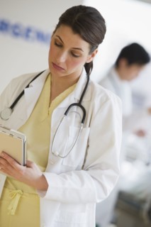 Doctor writing on chart.