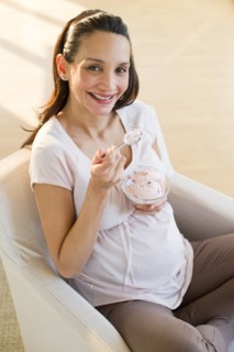 Pregnant woman eating a bowl of ice cream.