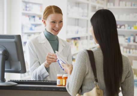 Pharmacist giving prescription to customer.
