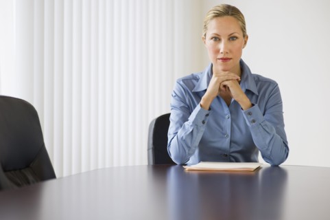 Businesswoman sitting at conference table.