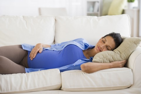 Pregnant woman napping on couch.