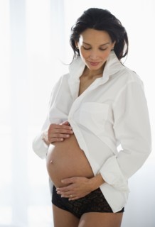 Pregnant woman holding her belly.