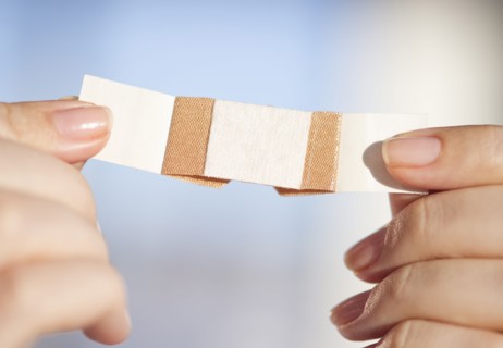 Hand holding band-aid.