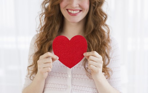Woman holding a red heart.