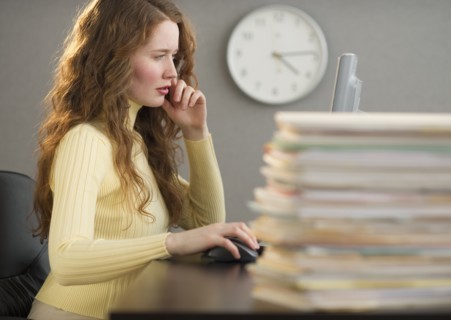 Overworked woman in cubicle.