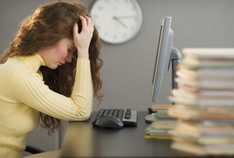 Overworked woman in cubicle.