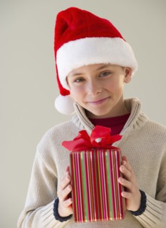 Young boy holding a Christmas present.