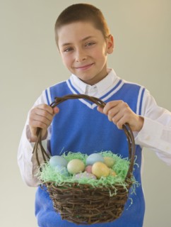 Young boy holding a basket of Easter eggs.