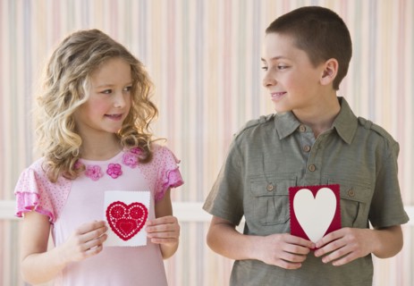 Young children holding Valentine cards.