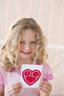 Young girl holding a Valentine card.