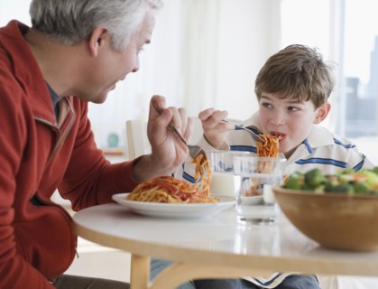 Father and son eating spaghetti. Photographe : Jamie Grill