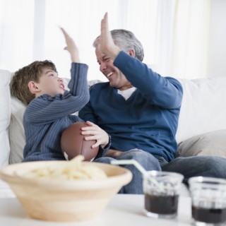 Father and son watching football game. Photographe : Jamie Grill