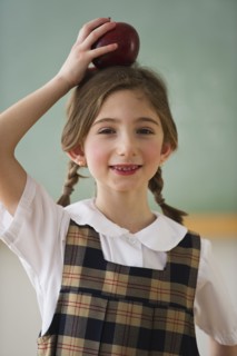 Child holding an apple on her head. Photographe : Daniel Grill