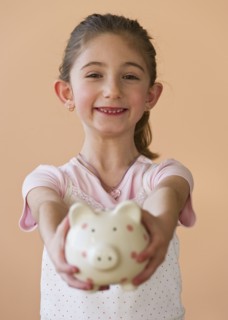 Young girl holding a piggy bank. Photographe : Daniel Grill