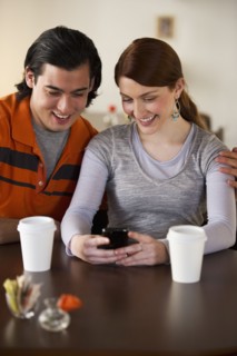 Couple reading text on cellular phone. Photographe : Daniel Grill