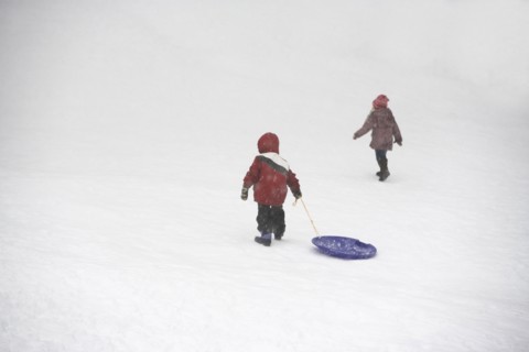 Kids pulling sled up snowy hill. Photographe : fotog