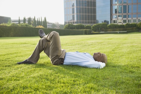 Businessman relaxing on lawn.