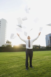 Businessman throwing papers in air.