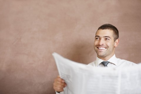Businessman reading newspaper. Photographe : momentimages