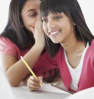 Students whispering classroom. Photographe : momentimages