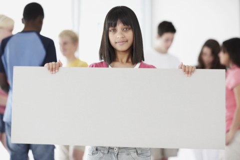 Young student holding blank billboard. Photographe : momentimages