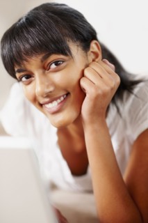 Young woman typing on laptop. Photographe : momentimages