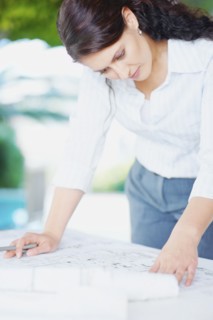 Woman looking at blueprints. Photographe : momentimages