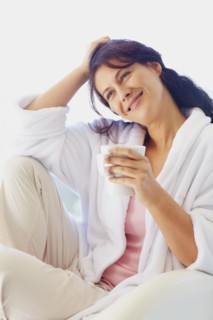 Woman in bathrobe drinking coffee. Photographe : momentimages