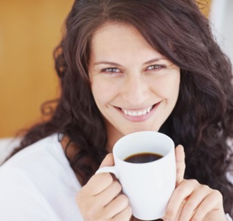 Relaxed woman drinking coffee. Photographe : momentimages