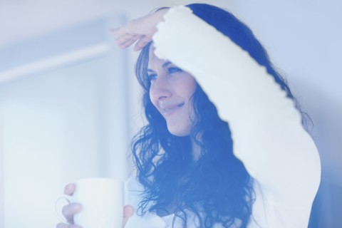 Woman looking out window. Photographe : momentimages