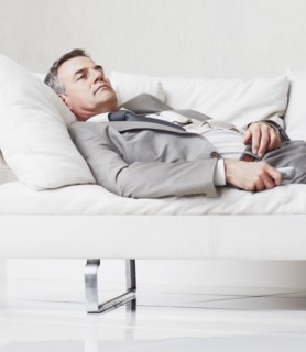 Businessman resting on couch. Photographe : momentimages