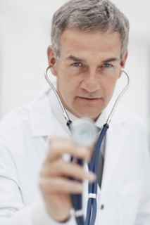 Doctor using stethoscope. Photographe : momentimages