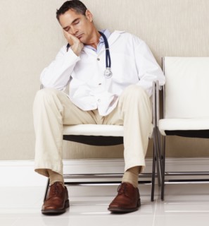 Doctor sitting in waiting room. Photographe : momentimages