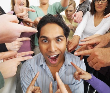 Group of people pointing at one person. Photographe : momentimages
