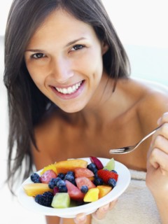 Woman eating fresh fruit. Photographe : momentimages