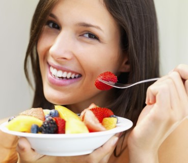 Woman eating fresh fruit. Photographe : momentimages