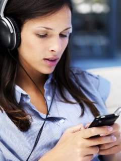 Woman listening to music on headphones. Photographe : momentimages