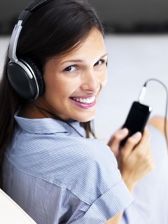 Woman listening to music on headphones. Photographe : momentimages
