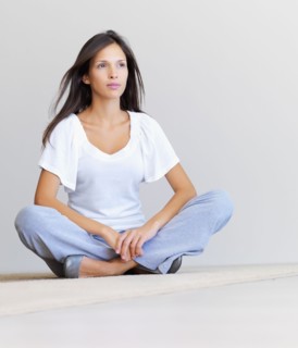 Woman sitting cross legged on floor. Photographe : momentimages
