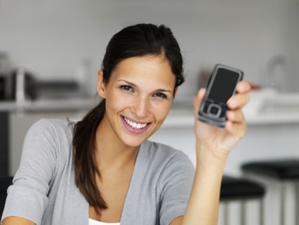 Woman holding cellular phone. Photographe : momentimages