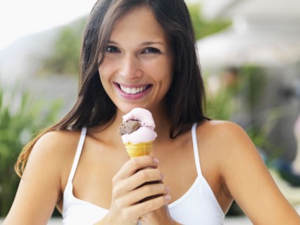 Woman eating ice cream cone. Photographe : momentimages
