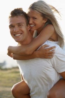 Man giving girlfriend a piggy back ride. Photographe : momentimages