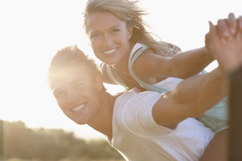 Man giving girlfriend a piggy back ride. Photographe : momentimages