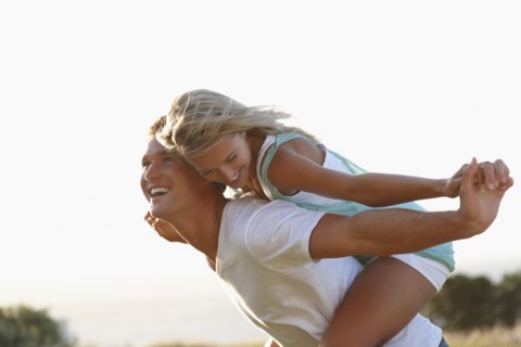Man giving girlfriend a piggy back ride. Photographe : momentimages