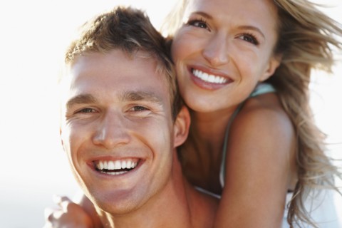 Man giving girlfriend a piggy back. Photographe : momentimages